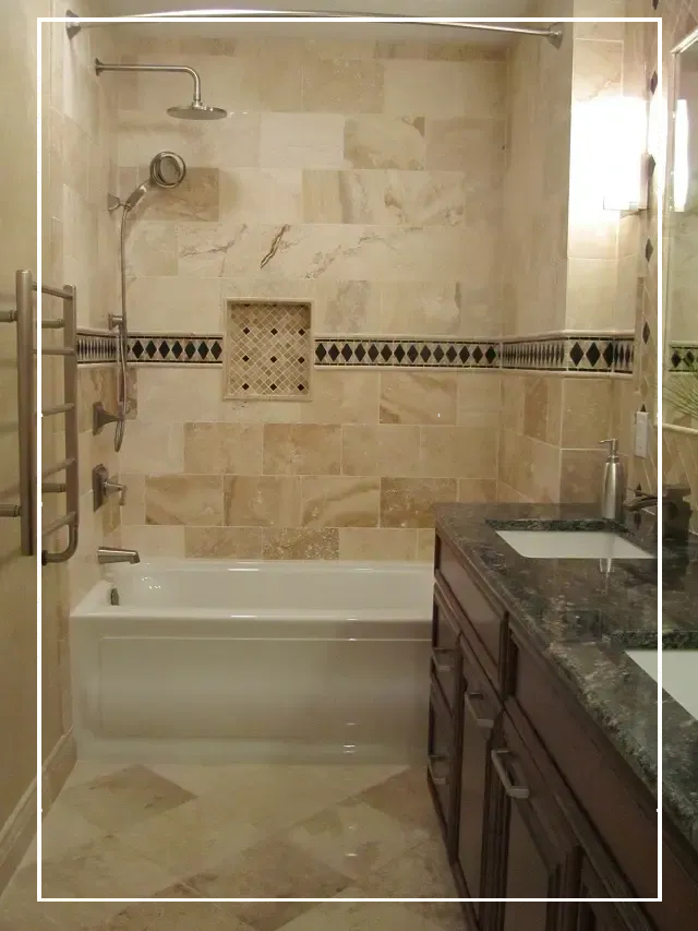 A bathroom with marble tile and granite counter tops.